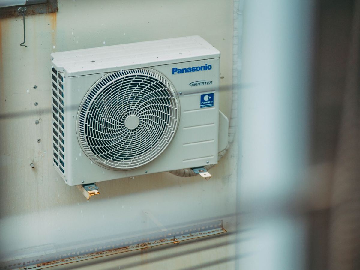 Outdoor mini-split condenser seen through a window