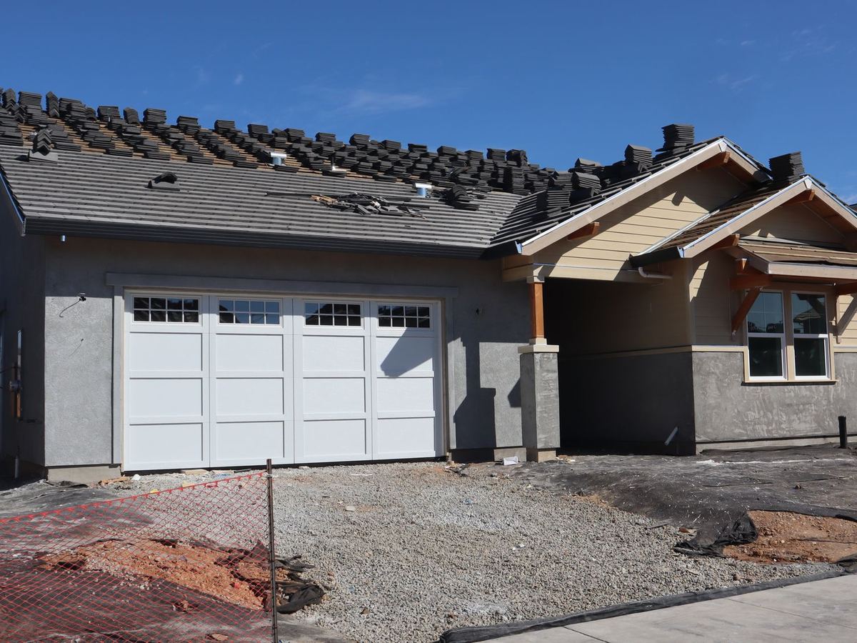 New home with roofing tiles being installed